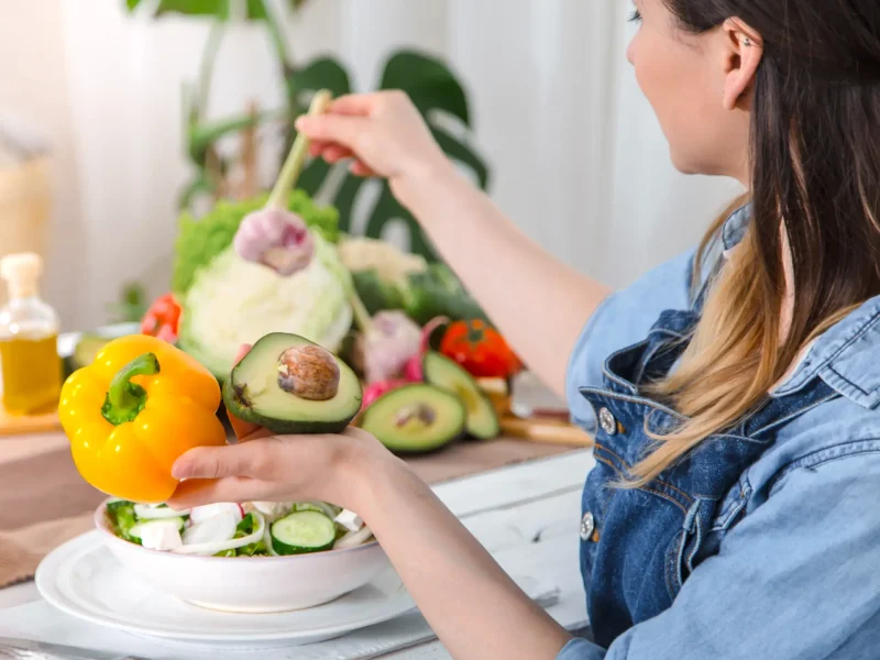 young-happy-woman-eating-salad-table